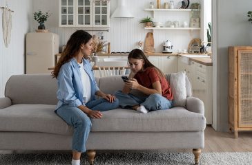mom and daughter looking at cell phone