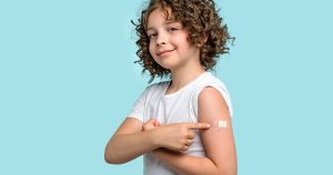 child pointing to bandaid covering immunization