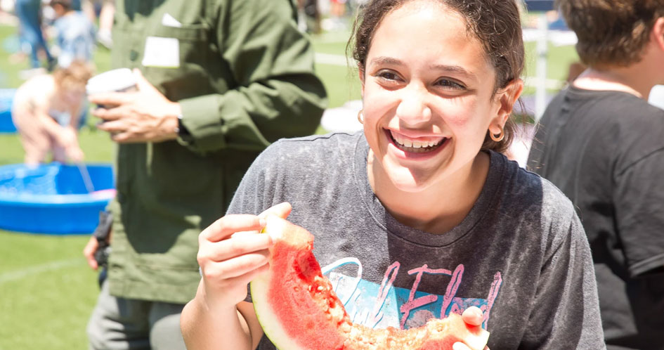 girl eating watermelon at PTA carnival